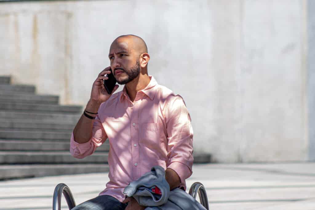 Hombre joven hablando por teléfono en una plaza